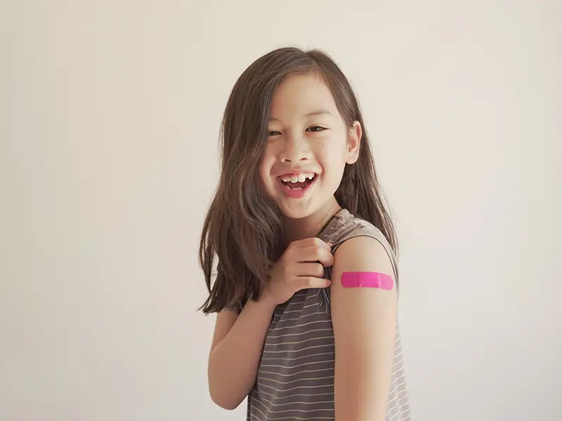Kid showing off her bandaid after getting vaccine